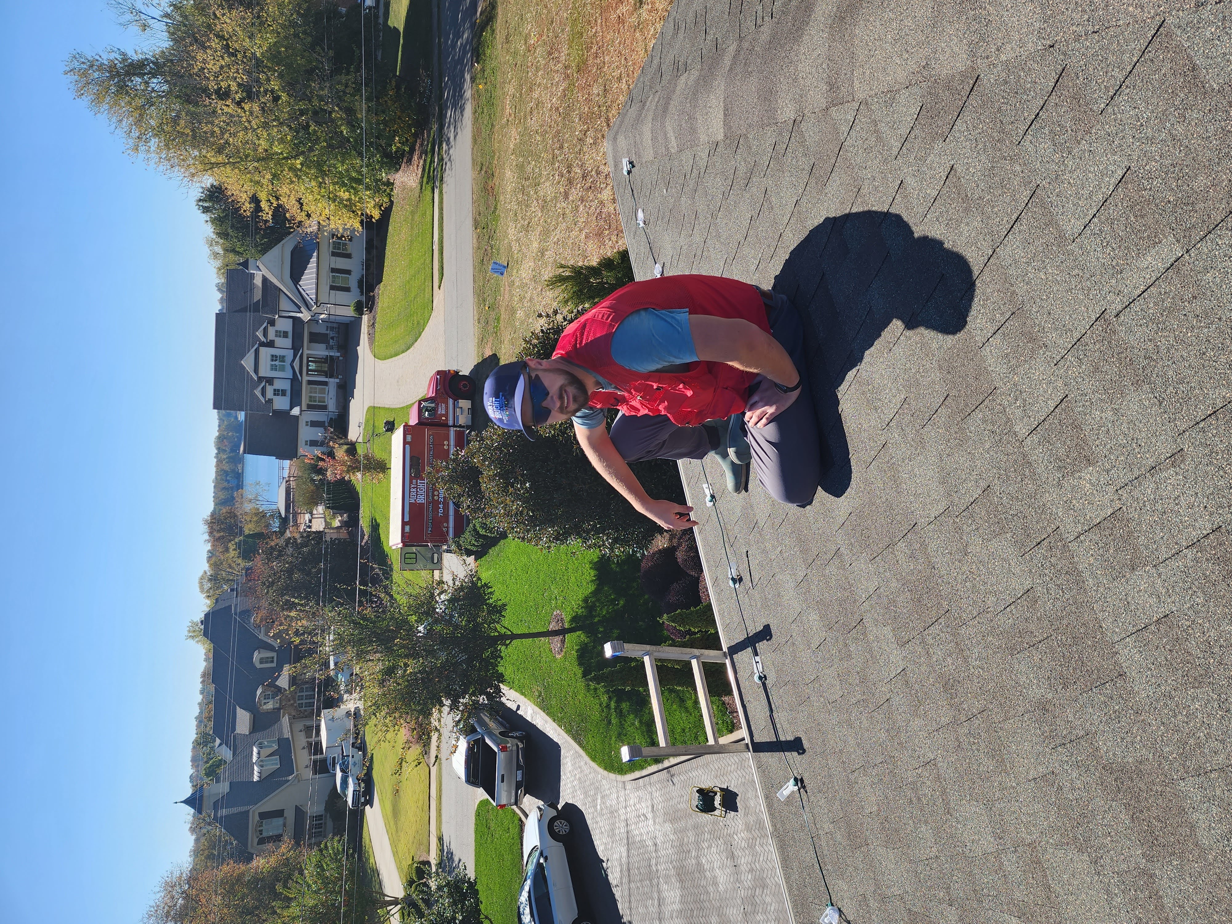 Tyler Wallace working on a Christmas light roofline installation